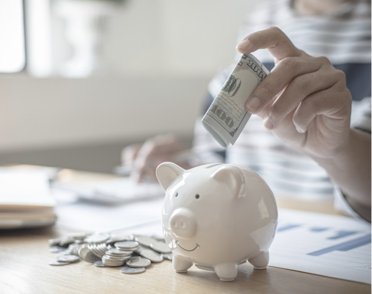 ブタの貯金箱にお札を入れる手